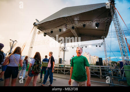 MINSK, Weißrussland - Mai 9, 2014: Junge Menschen tanzen im Regen vor dem Palast des Sports. Stockfoto