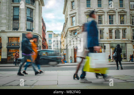 Bewegung verwischt Shopper hinunter high end London High Street Stockfoto