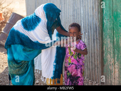 Die somalische Mutter waschen das Gesicht ihrer Tochter außerhalb Ihres Hauses, Woqooyi Galbeed Provinz, Baligubadle, Somaliland Stockfoto