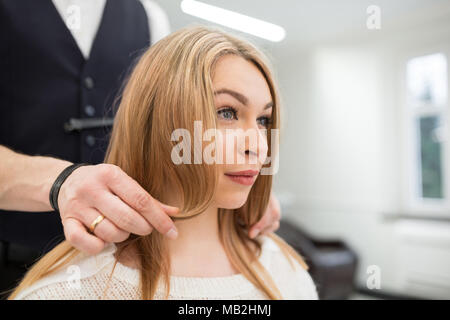 Porträt der jungen Frau, die für das Erhalten der Haarschnitt vorbereitet wird. Stockfoto