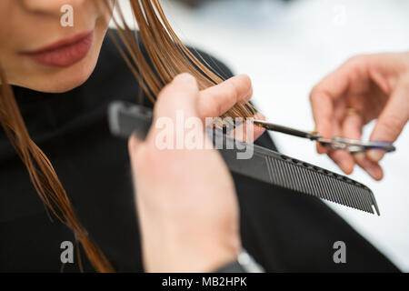 Close up Portrait von Friseur Hände schneiden junge Mädchen Haar Stockfoto