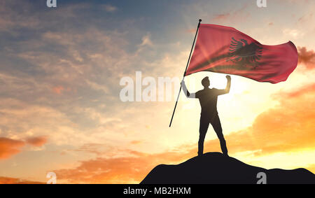 Albanien Flagge geschwenkt werden von einem Mann Erfolg feiern auf der Spitze eines Berges. 3D-Rendering Stockfoto