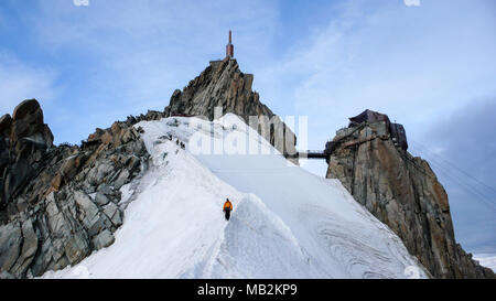Bergführer und ein männlicher Client auf einem felsigen Grat in Richtung hoher Gipfel in den französischen Alpen in der Nähe von Chamonix. Stockfoto