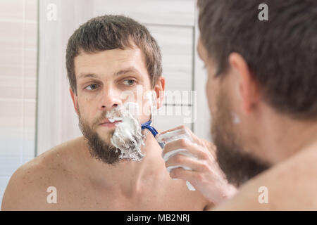 Ein Mann rasiert sich den Bart sehr starke Stockfoto