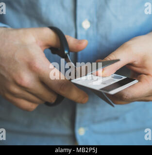 Man schneiden Kreditkarte mit einer Schere. Stockfoto