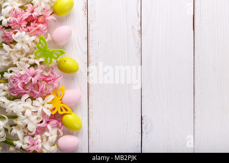 Ostern Hintergrund mit bunten Eiern, Hyazinthen Blumen und Schmetterlinge auf weißem Holz- Hintergrund Stockfoto