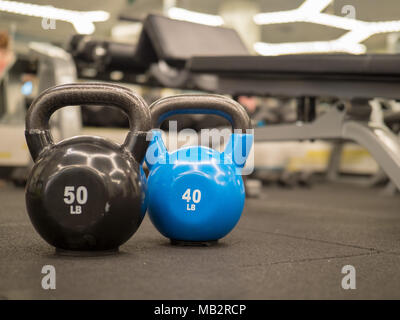 Reihe von Kettlebells in einen modernen Fitnessraum. 50 und 40 lbs Stockfoto
