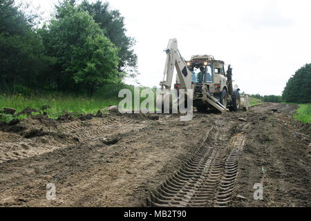 Ein Soldat mit Alpha Company, 766th Engineer Brigade Bataillon von Marseille, Illinois, verwendet eine hohe Mobilität Ingenieur Hydraulikbagger (HMEE) - einem Baggerlader entwickelt speziell für das US-Militär - eine Straße Juni 8, 2015 umzubauen, am Fort McCoy, Wis., die Arbeit ist Teil einer Truppe Projekt Straßen zu reparieren und Wanderwege auf Fort McCoy's South Post. Zahlreiche Soldaten aus der 766Th die HMEE, ein Sortierer verwendet, Muldenkipper, und mehrere andere Stücke von schwerem Gerät die Reparaturen abgeschlossen. Die 766Th ist ein Illinois National Guard Einheit, die im Rahmen der 33. Brigade Combat Team fällt und ist spezialisiert auf die Unterstützung von Stockfoto