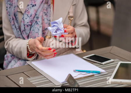 In der Nähe der weiblichen Händen. Die Women's Händen zerbricht eine falsch geschriebene Dokument. Stockfoto