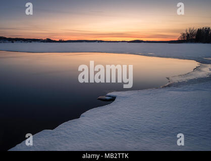 Die malerische Landschaft mit geschmolzener See ein Sonnenuntergang am Abend in Finnland Stockfoto