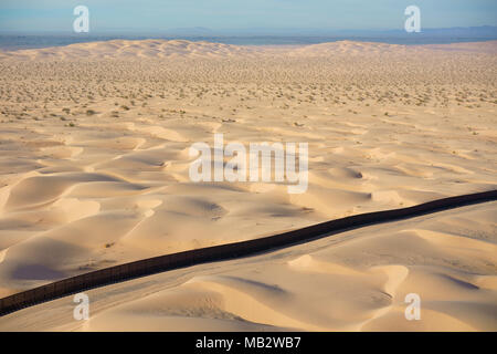 LUFTAUFNAHME. Internationale Grenze zwischen Mexiko (hinter der Mauer) und den Vereinigten Staaten. Algodones Dunes, Sonoran Desert, Baja California, Mexiko. Stockfoto