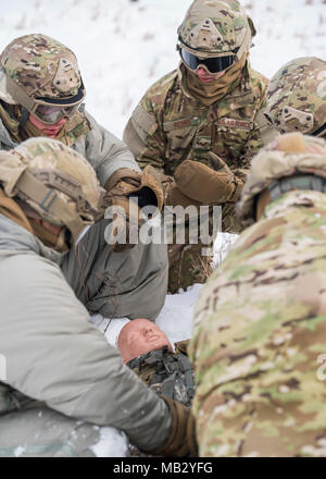 Die 91 Mitglieder der Sicherheitskräfte Gruppe durchführen Selbsthilfeorganisationen buddy Care auf einem simulierten Unfall im Turtle Mountain State Forest, N.D., 14.02.2018. Nach der Stabilisierung der Unfallversicherung, Verteidiger vektorisierte in einem Rettungshubschrauber für den Notfall medizinische Evakuierung. Stockfoto