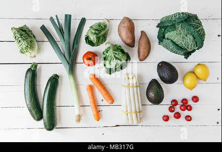 Flach der arrangierten frischen Gemüse um liegen auf weißem Holz. Stockfoto