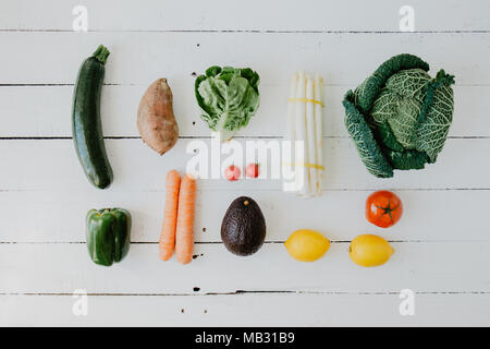 Flach der arrangierten frischen Gemüse um liegen auf weißem Holz. Stockfoto