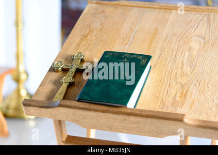 Goldenes Kreuz Kruzifix mit Bibel auf Holztisch. Christliche Kirche religion Konzept. Stockfoto