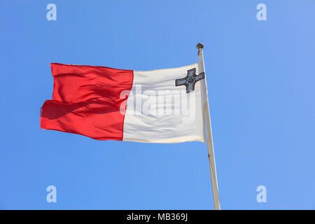 Malta Flagge. Malta Flagge an einem Fahnenmast winken in der entgegengesetzten Richtung auf einem blauen Himmel Hintergrund Stockfoto