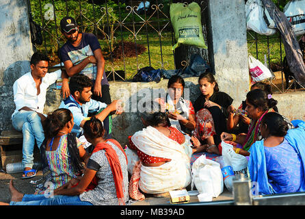 Eine Gruppe von Leuten, die sich die Zeit nehmen, Karten zu spielen und auf eine Stadtstraße, Mumbai, Indien Stockfoto