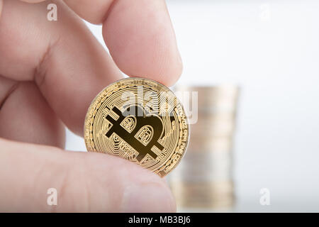 Geschäftsmann holding Bitcoin auf grauem Hintergrund. Golden bitcoin Münzen in die Hände des Menschen. Virtuelle Währung Stockfoto