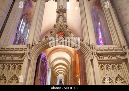 NORWICH, UK - 31. MÄRZ 2018: Trinity Windows (mit hellen Farben), die Kathedrale von innen, durch einen Bogen mit Schnitzereien gesehen Stockfoto