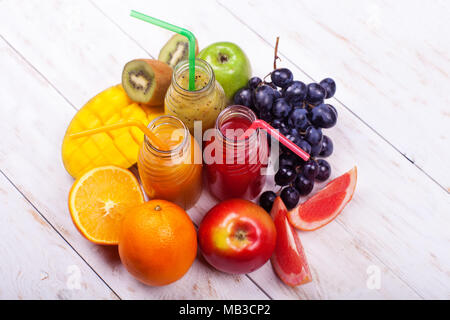 Zeile frische Säfte Smoothie drei Flaschen Rot Grün Orange Früchte Vitamine gesunde Konzept auf Weiß. Stockfoto