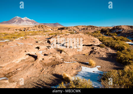 Felsformationen von trockenen Lava, mit Cerro Miniques (Miniques Hill) in den Hintergrund in den Anden Altiplano (Hochebene), Los Flamencos nationalen Rese Stockfoto