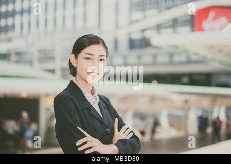 Moderne asiatische Geschäft im Freien stehende Frau mit Bürogebäude im Hintergrund Kopie Raum vintage Tone Stockfoto