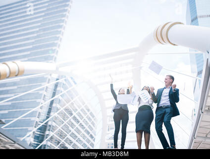 Geschäft Leute feiern, durch das Werfen von Papieren in der Luft in Stadt Gebäude anzeigen Stockfoto