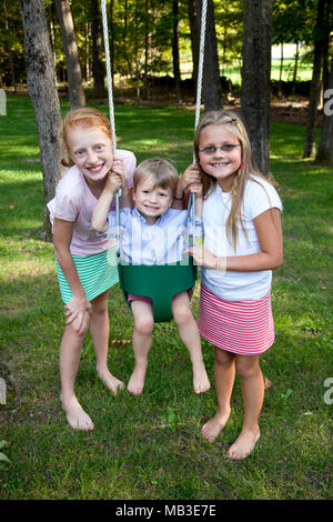 Zwei lächelnde Mädchen posiert mit jungen in Swing Stockfoto