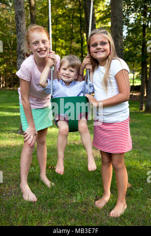 Zwei lächelnde Mädchen posiert mit jungen in Swing Stockfoto