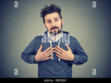 Treuer Mann hält die Hände auf der Brust in der Nähe von Herz, zeigt Güte aufrichtiger Gefühle ausdrückt, die gutherzige und ehrlich. Stockfoto