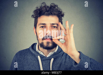 Zuversichtlich ernster Mann zippen Mund halten vertrauliche Daten Kamera schaut. Stockfoto