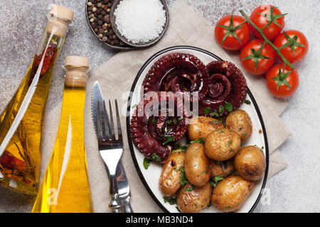 Gegrillter Tintenfisch mit kleinen Kartoffeln mit Kräutern und Gewürzen. Ansicht von oben Stockfoto