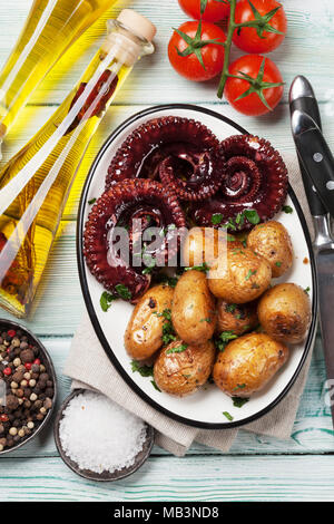 Gegrillter Tintenfisch mit kleinen Kartoffeln mit Kräutern und Gewürzen. Ansicht von oben Stockfoto