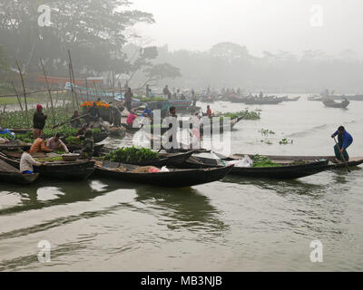 Morgen in der schwimmenden Markt. Im Delta der Flüsse Ganga (Padma), Brahmaputra und Meghna Menschen leben auf dem Wasser. Bereich rund um die Stadt Banaripara mit Wasser geflutet wird. Die Menschen leben in Dörfern am Ufer des Flusses. Kein Straßenverkehr ist möglich. Nur Wasser und Schiffe verbinden Sie mit dem Rest der Welt. Aber die Gegend ist sehr lebhaft. Die Landwirte beim Anbau von Obst, Gemüse, Reis und Getreide auf 2 700 Quadratkilometer Land unter den Fluss. Anbieter besuchen ihre Kunden auf Booten. Schwimmende Märkte mit Gemüse, Obst, Reis oder Holz sind in diesem Bereich. Menschen bauen Schiffe hier, Stockfoto