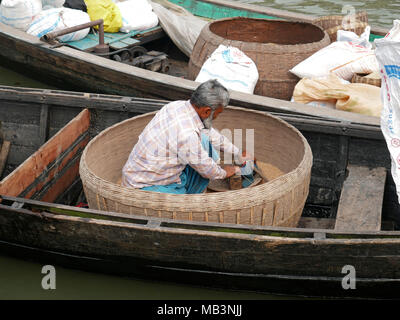 Reis Reis Anbieter auf dem schwimmenden Markt. Im Delta der Flüsse Ganga (Padma), Brahmaputra und Meghna Menschen leben auf dem Wasser. Bereich rund um die Stadt Banaripara mit Wasser geflutet wird. Die Menschen leben in Dörfern am Ufer des Flusses. Kein Straßenverkehr ist möglich. Nur Wasser und Schiffe verbinden Sie mit dem Rest der Welt. Aber die Gegend ist sehr lebhaft. Die Landwirte beim Anbau von Obst, Gemüse, Reis und Getreide auf 2 700 Quadratkilometer Land unter den Fluss. Anbieter besuchen ihre Kunden auf Booten. Schwimmende Märkte mit Gemüse, Obst, Reis oder Holz sind in diesem Bereich. Menschen bauen Shi Stockfoto