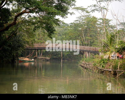 Eine Brücke in die backwaters Bereich gesehen. Im Delta der Flüsse Ganga (Padma), Brahmaputra und Meghna Menschen leben auf dem Wasser. Bereich rund um die Stadt Banaripara mit Wasser geflutet wird. Die Menschen leben in Dörfern am Ufer des Flusses. Kein Straßenverkehr ist möglich. Nur Wasser und Schiffe verbinden Sie mit dem Rest der Welt. Aber die Gegend ist sehr lebhaft. Die Landwirte beim Anbau von Obst, Gemüse, Reis und Getreide auf 2 700 Quadratkilometer Land unter den Fluss. Anbieter besuchen ihre Kunden auf Booten. Schwimmende Märkte mit Gemüse, Obst, Reis oder Holz sind in diesem Bereich. Menschen bauen Schiffe Stockfoto