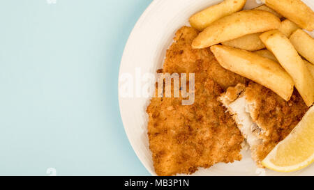 Traditionell beliebten Fisch und Chips vor einem blauen Hintergrund Stockfoto