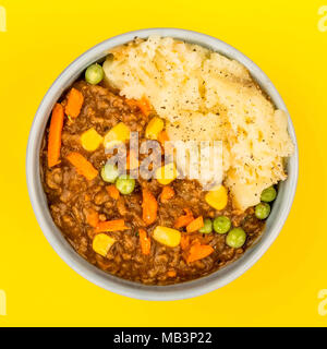 Pflegende Cottage Pie Mahlzeit in einer Schüssel auf gelbem Hintergrund Stockfoto