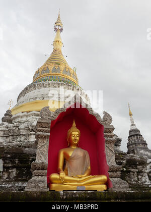 Golden Buddha Bild im roten Bogen über das stupa oder Pagode und Himmel Hintergrund in Buppharam Tempel, das beliebte Ausflugsziel in Chiang Mai, Thailand Stockfoto