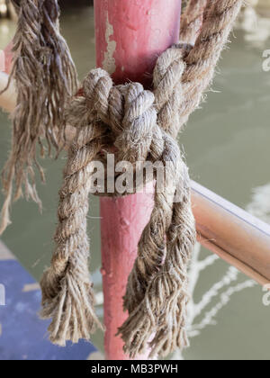 Hanf Seil gebunden zusammen auf rot Stahlmast auf floss in Net Shape, um zu verhindern, dass jemand ins Wasser über den ländlichen Raum Hintergrund Stockfoto