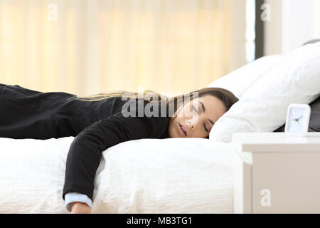 Müde Geschäftsfrau liegen auf einem Bett nach einem schlechten Tag. Stockfoto