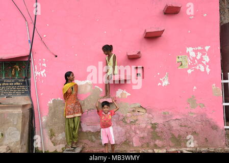 Indische Kinder gegen eine rosa Wand in Abhaneri, Rajasthan, Indien posieren. Stockfoto