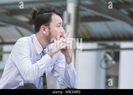 Junge asiatische Geschäftsmann in tiefe Verzweiflung Stockfoto