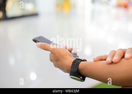 Mann asiatischen mit Telefon für Decke und Textnachrichten auf Ihr Mobiltelefon Stockfoto