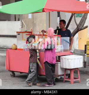 Familie Einkauf kalte Getränke aus einem street Hawker in einem heißen Nachmittag. Stockfoto