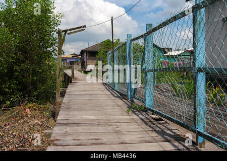 Gehweg aus Holzplanken an Crab Island, einem berühmten Fischerdorf in Malaysia. Stockfoto