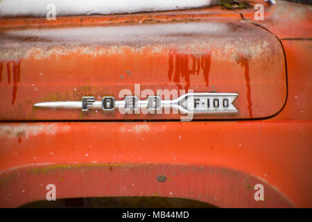 Eine alte, rote 1960er Ford F-100 Pickup Truck, im Schnee, auf der Seite einer Scheune, in der Noxon, Montana. Dieses Bild wurde mit einem antiken Petzval objektiv geschossen und Stockfoto