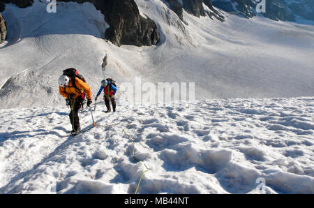 Bergführer und client Position auf einem Gletscher in Richtung einer hochalpinen Gipfel an einem schönen Sommermorgen Stockfoto