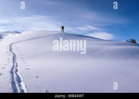 Ein backcountry skier Wandern auf einem langen Grat auf den Gipfel in der Nähe von Klosters in den Schweizer Alpen im tiefen Winter Stockfoto