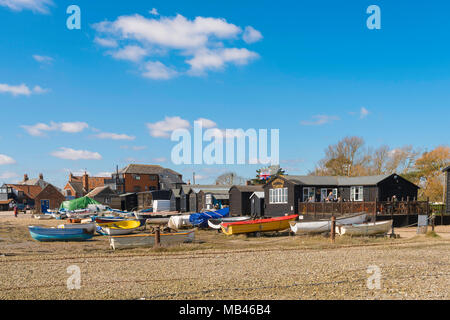 Suffolk UK Strand, Blick auf die bunten Boote und ein Kaffee shop am Strand von Orford Quay, Suffolk, East Anglia, England, UK. Stockfoto